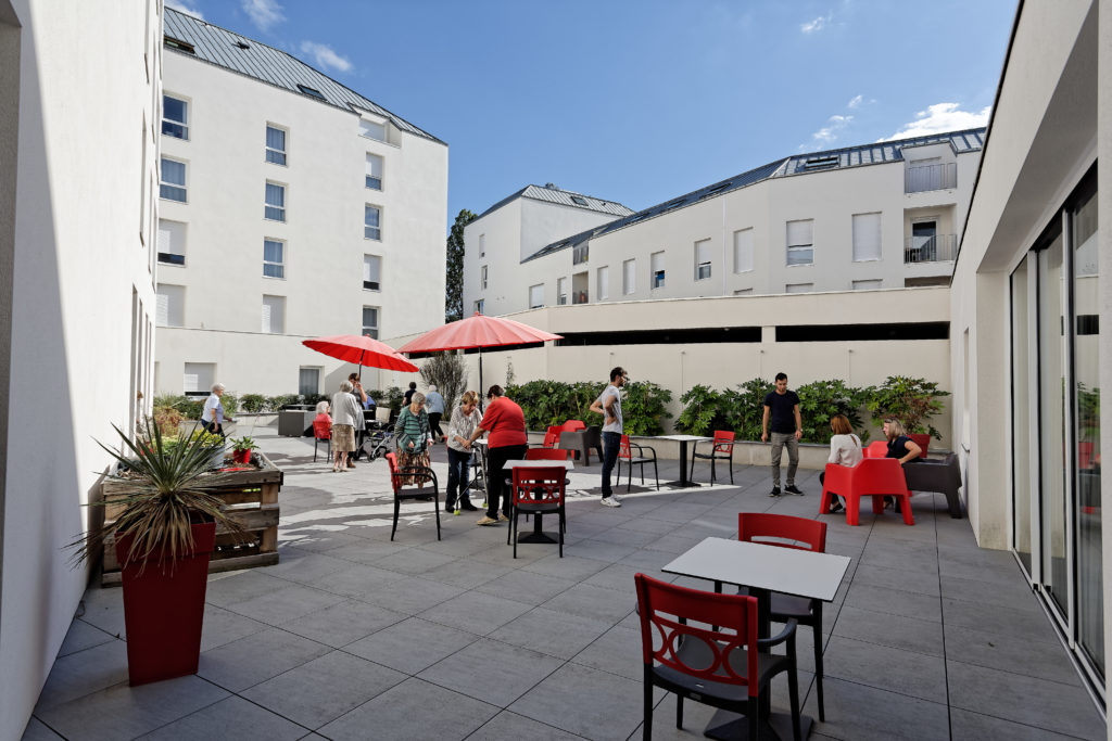 Terrasse fleurie d'une résidence aux façades blanches