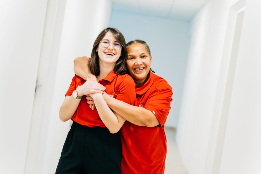 Portrait de deux collaboratrices souriantes en tenue rouge