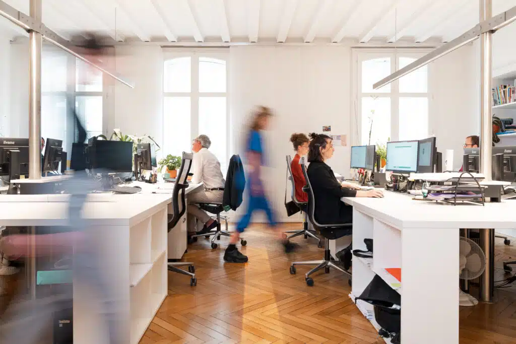 Bureaux en open space avec des collaborateurs en mouvement