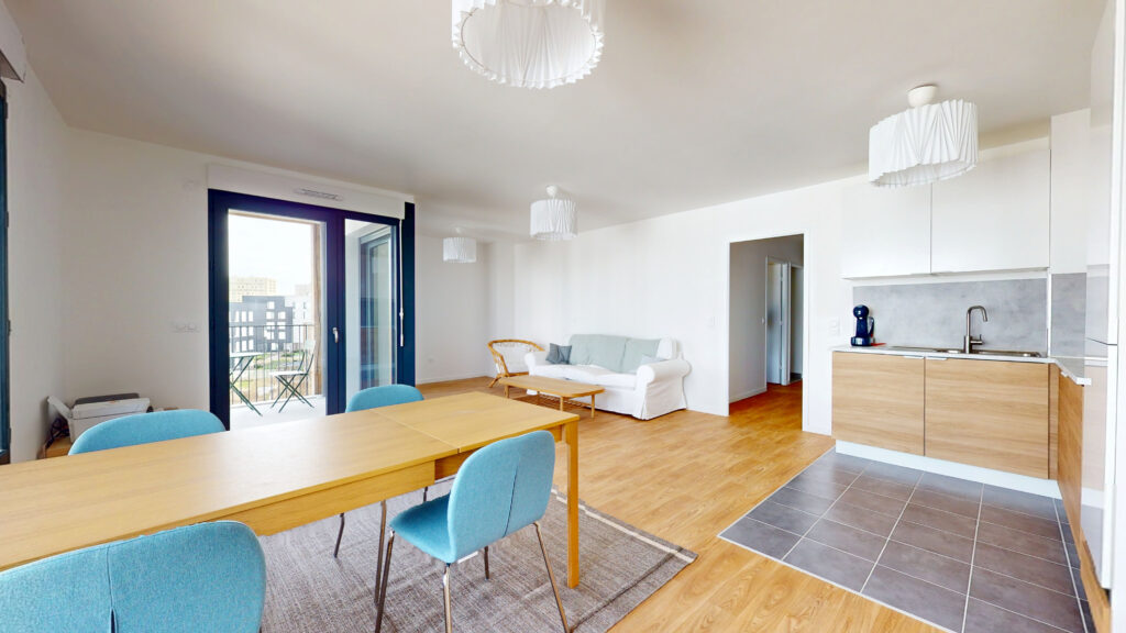 Séjour lumineux d'un appartement parisien avec cuisine ouverte